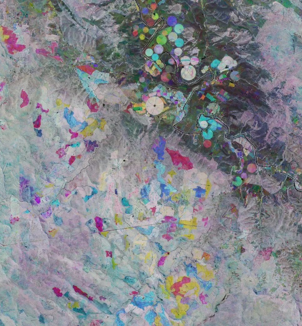 False-colour satellite composite of mountainous terrain threaded with rivers and cleared land